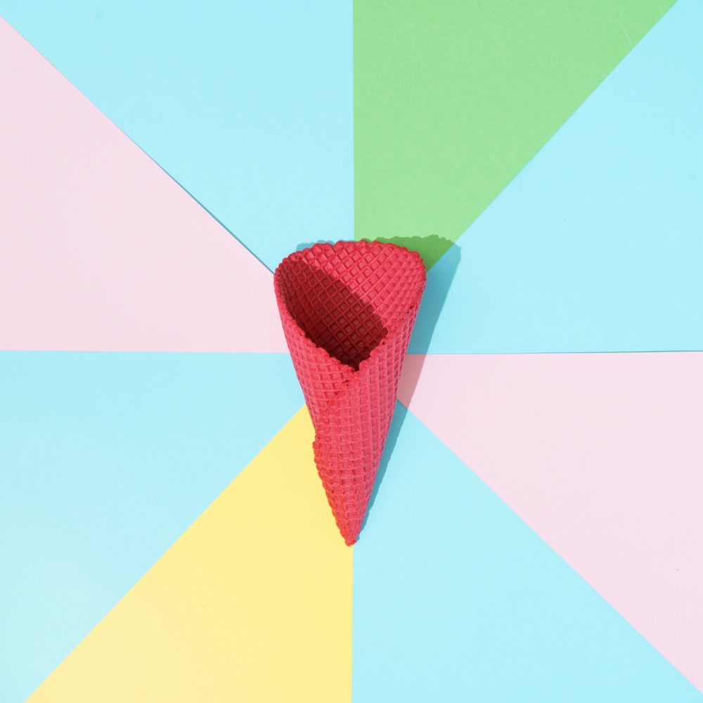 Abstract minimal background in pastel colors with red ice cream cone. Minimal summer flat lay
