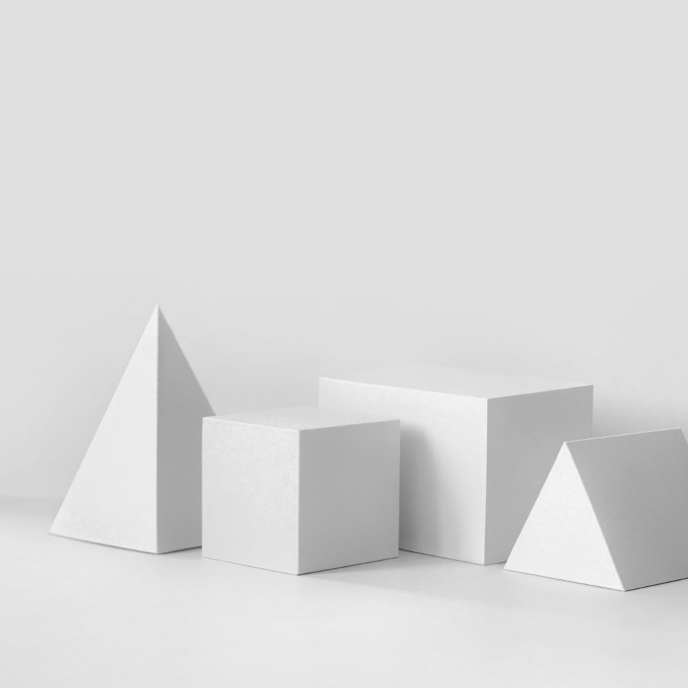 White geometrical figures still life composition. Prism pyramid rectangular cube objects, copy space