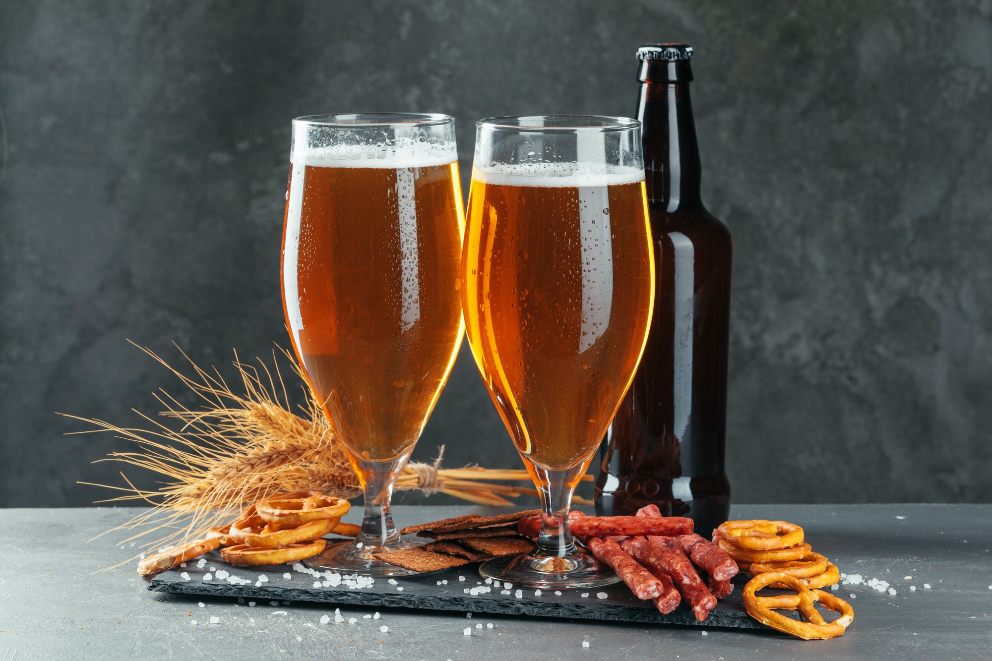 beer and appetizing beer snacks set. Table with mug of beer, wooden board with sausages