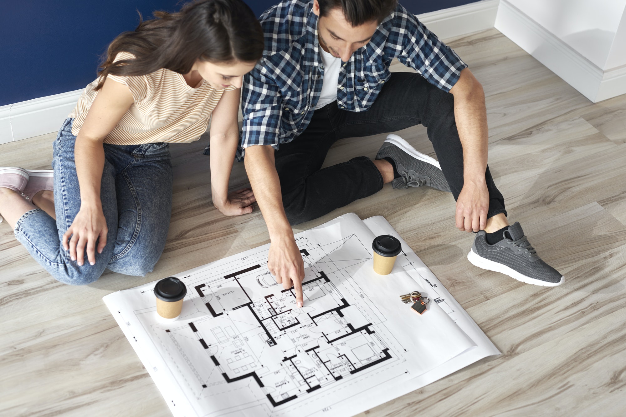 Couple looking at blueprint in new house