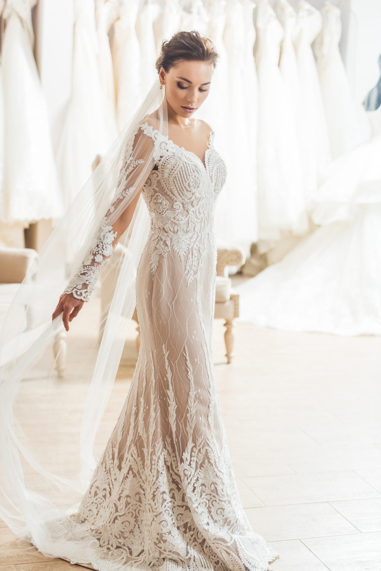 Stylish bride in lace dress in wedding atelier