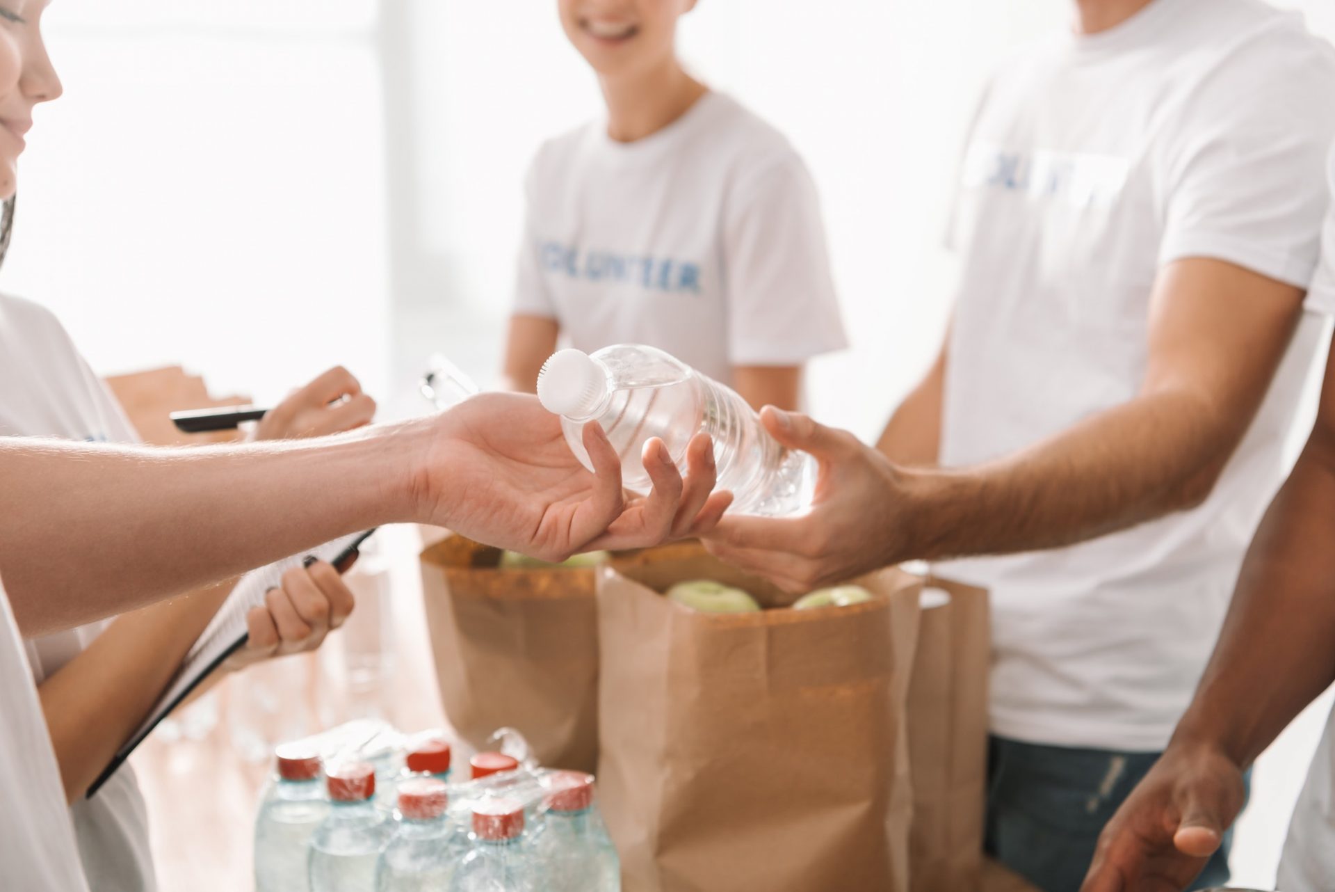 cropped shot of volunteers with food and drinks for charity