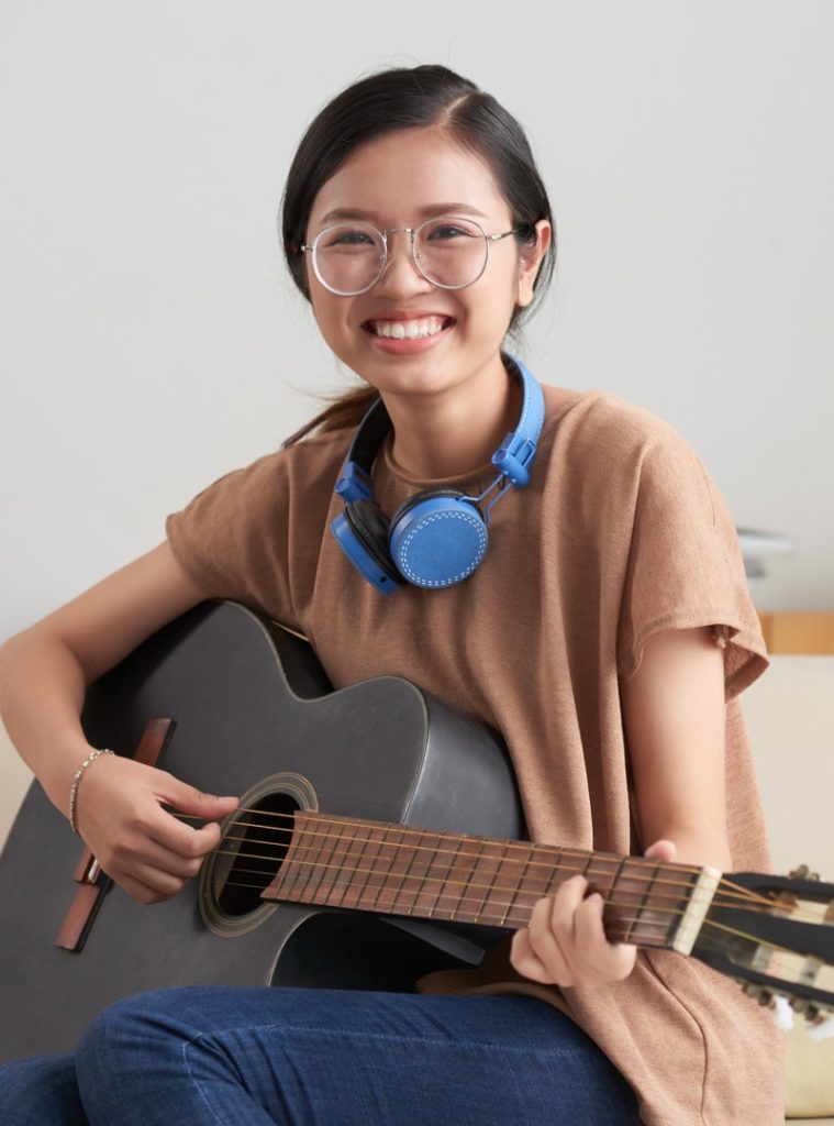Asian woman playing guitar