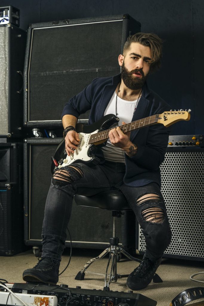 Bearded man playing guitar in a music studio