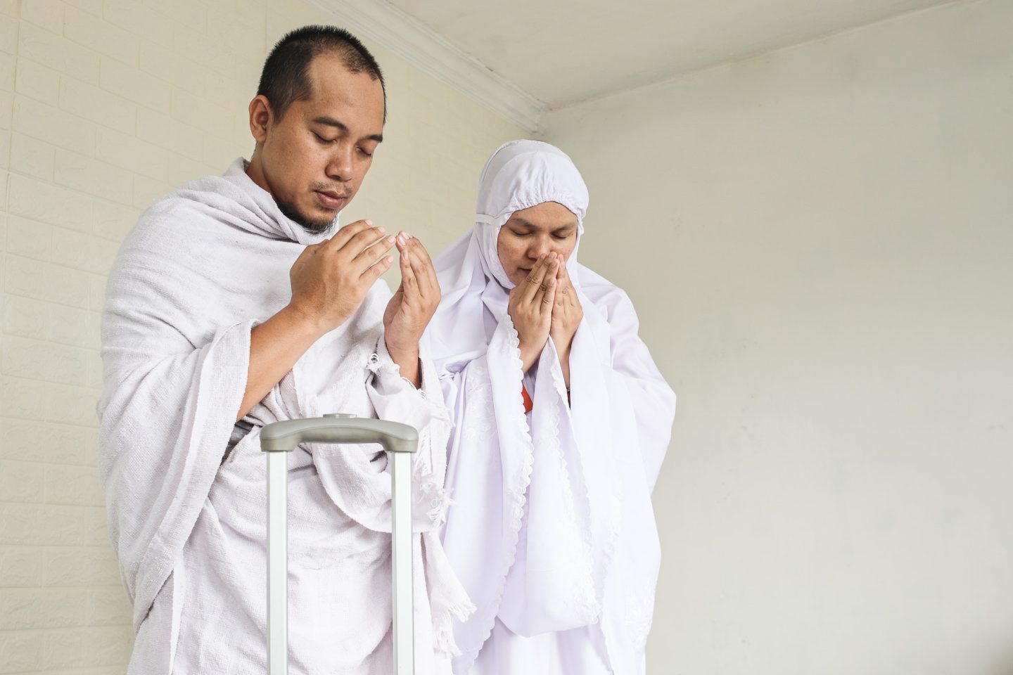 Muslim couple praying before umrah or hajj