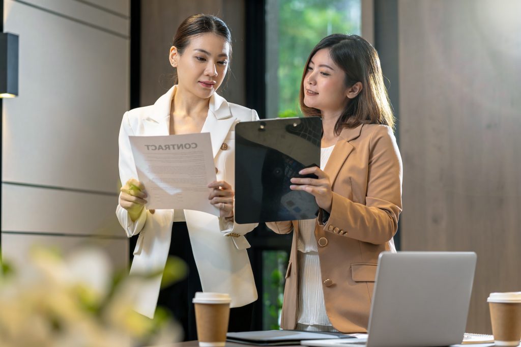 Two asian businesswomen discussing with the partner business about business contract