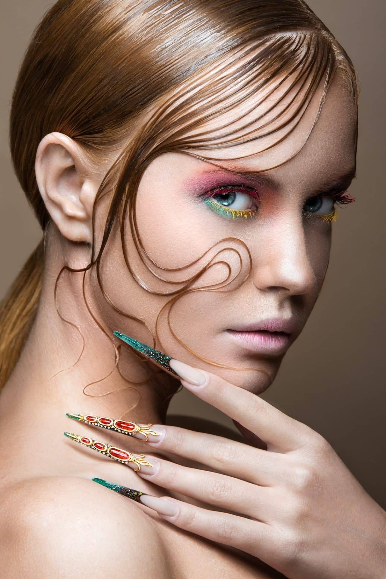 Beautiful girl with bright fashion make-up, creative hairstyle, long nails. Design manicure.