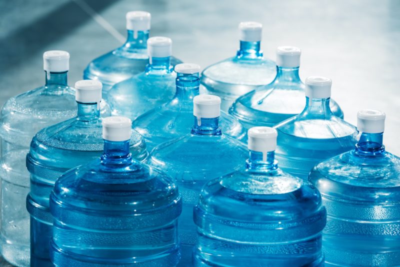 Plastic large blue water bottles on floor