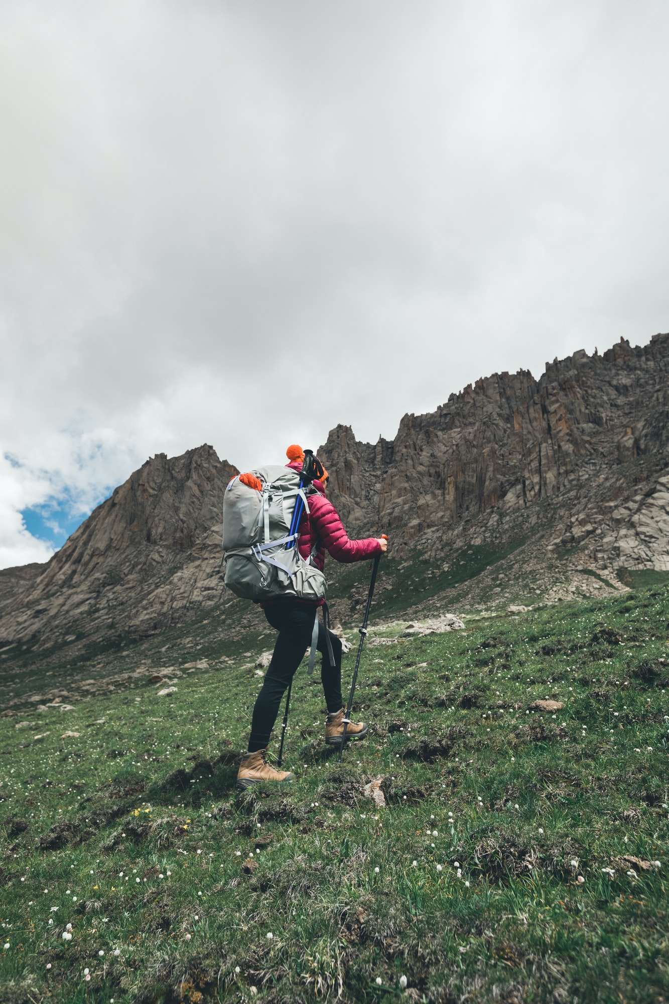 Backpacking woman ascent on high altitude mountains