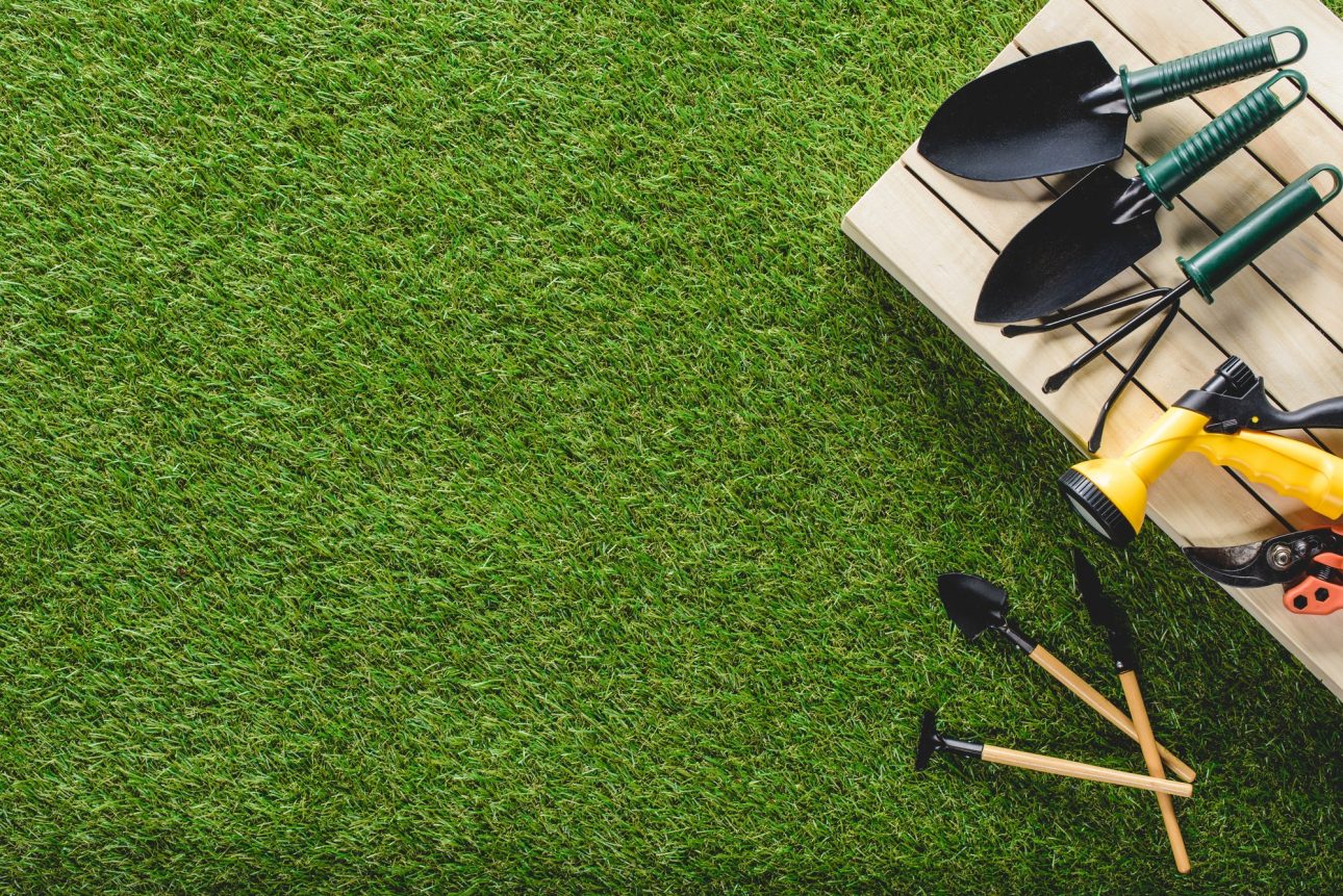 top view of gardening tools and equipment on grass