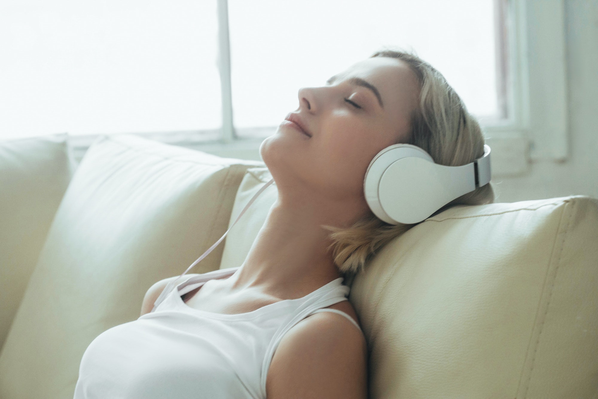 Woman in headphones at home listening to music, relax alone close up portrait.