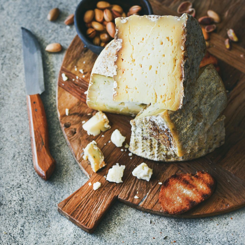Cheese platter with nuts, honey and bread, square crop