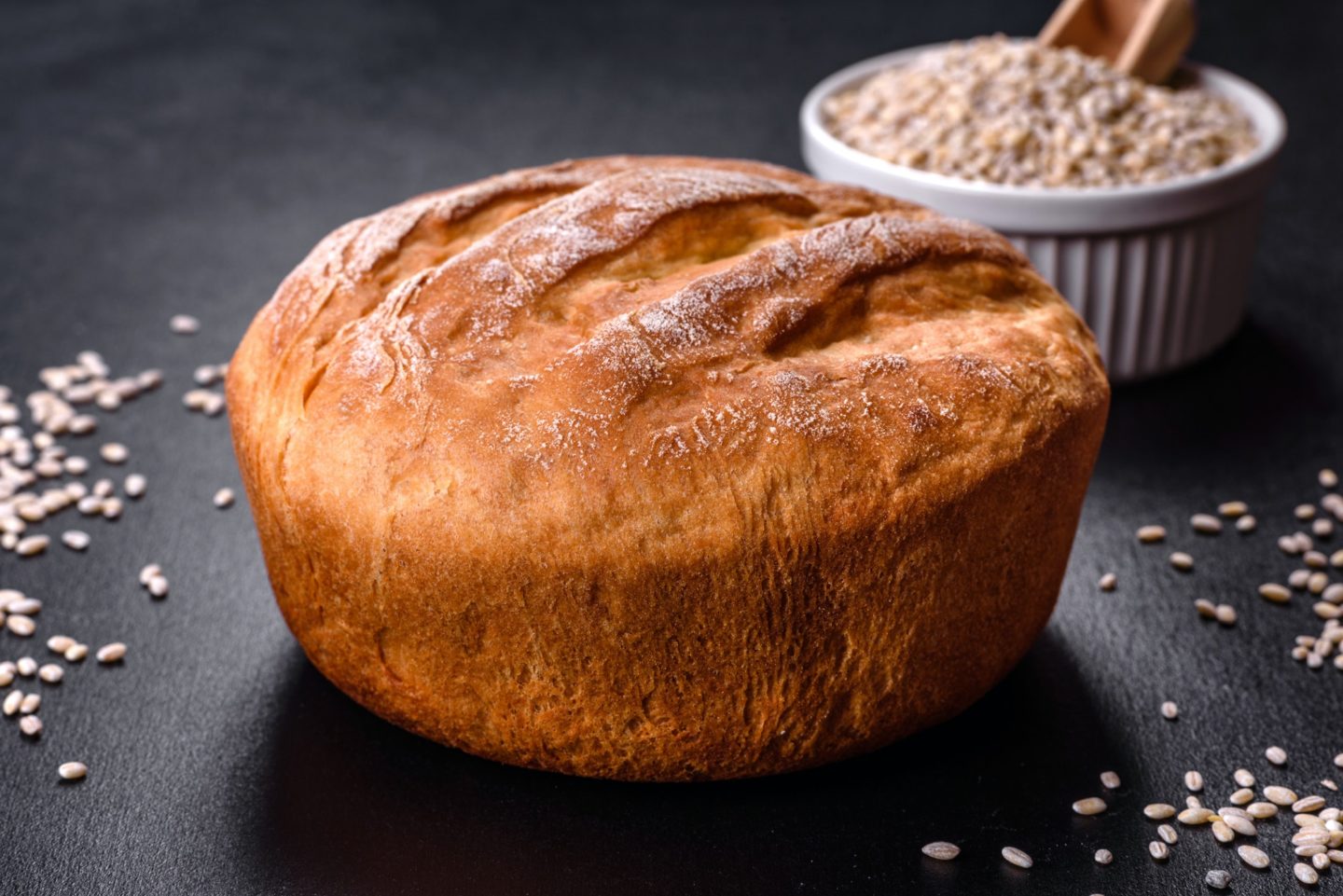 Tasty fresh baked in oven white bread on a dark concrete background