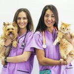 Cheerful women veterinary holding her pets.