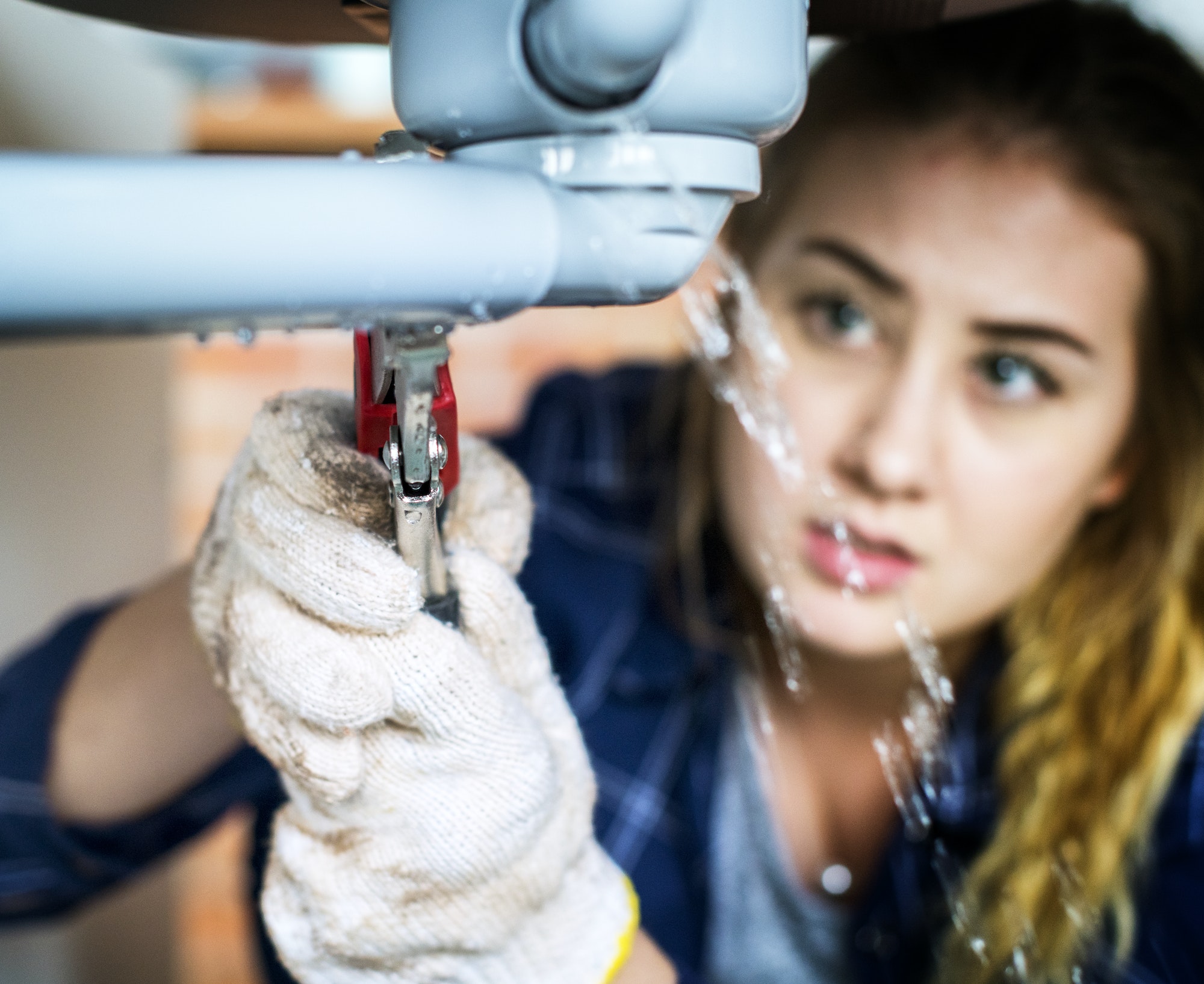 Woman fixing kitchen sink