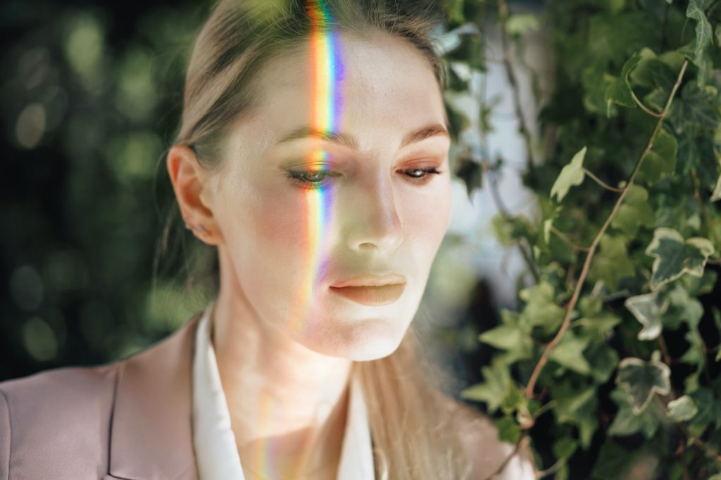 Portrait of an attractive woman with rainbow light across face