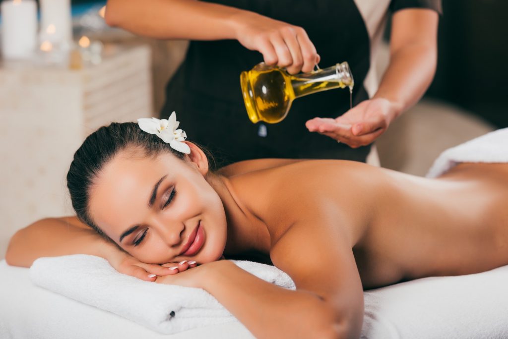 relaxing woman having massage therapy with body oil