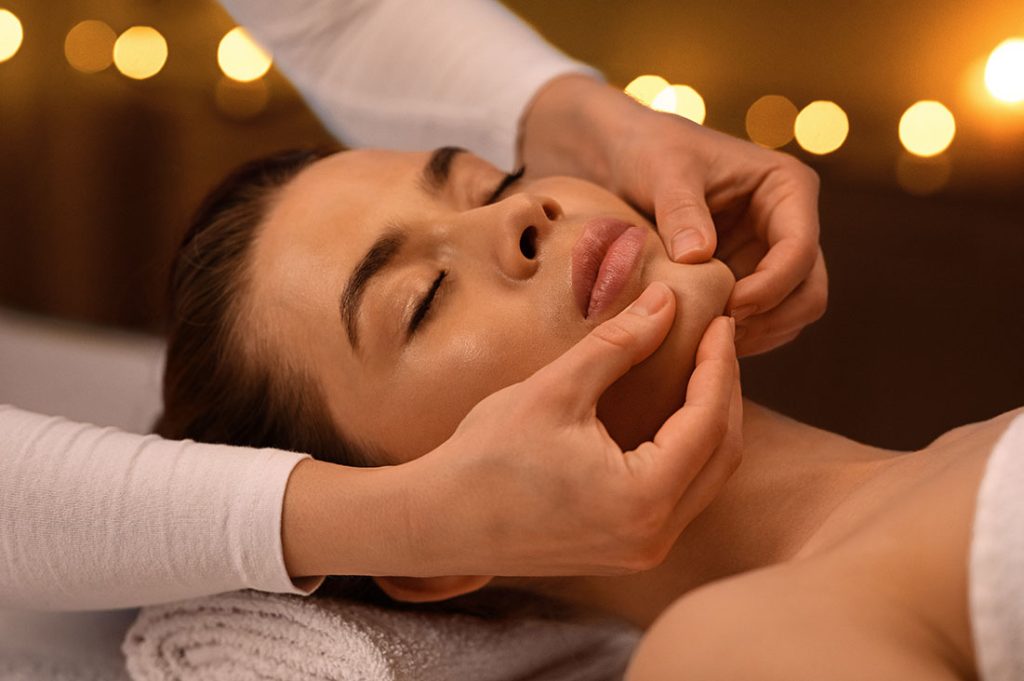 relaxed-woman-getting-healing-face-massage-at-spa-8U8FCM6