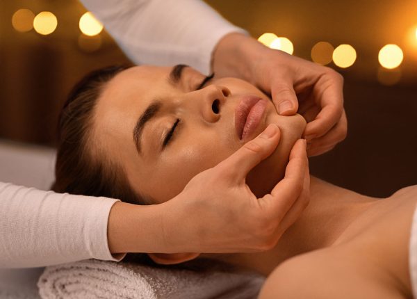 relaxed-woman-getting-healing-face-massage-at-spa-8U8FCM6