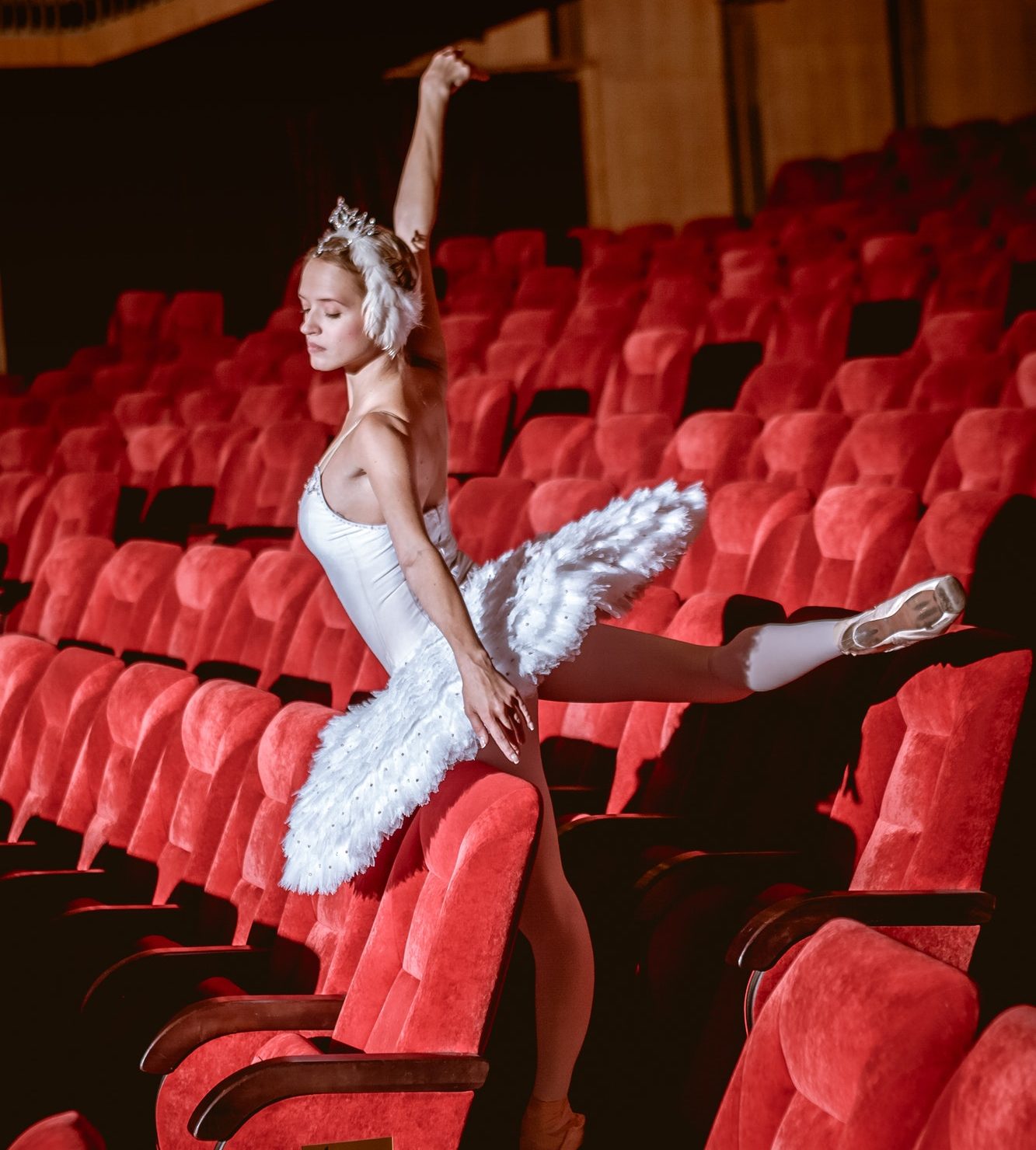 Ballerina sitting in the empty auditorium theater