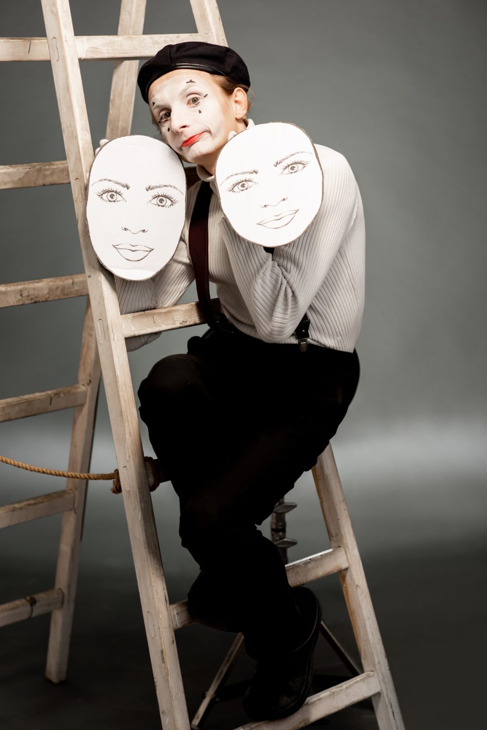 Portrait of an actor with facial masks on the grey background