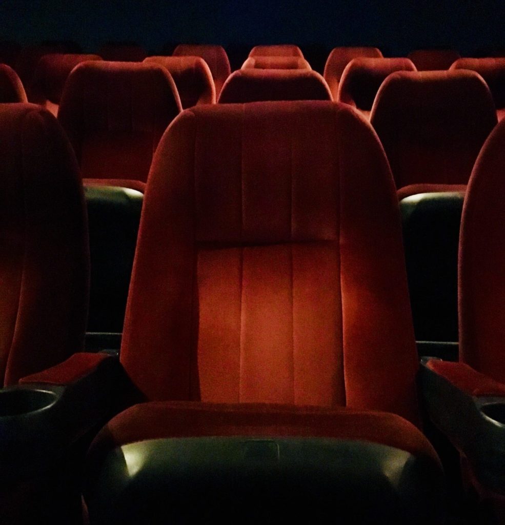 Rows of red seats at movie theatre.