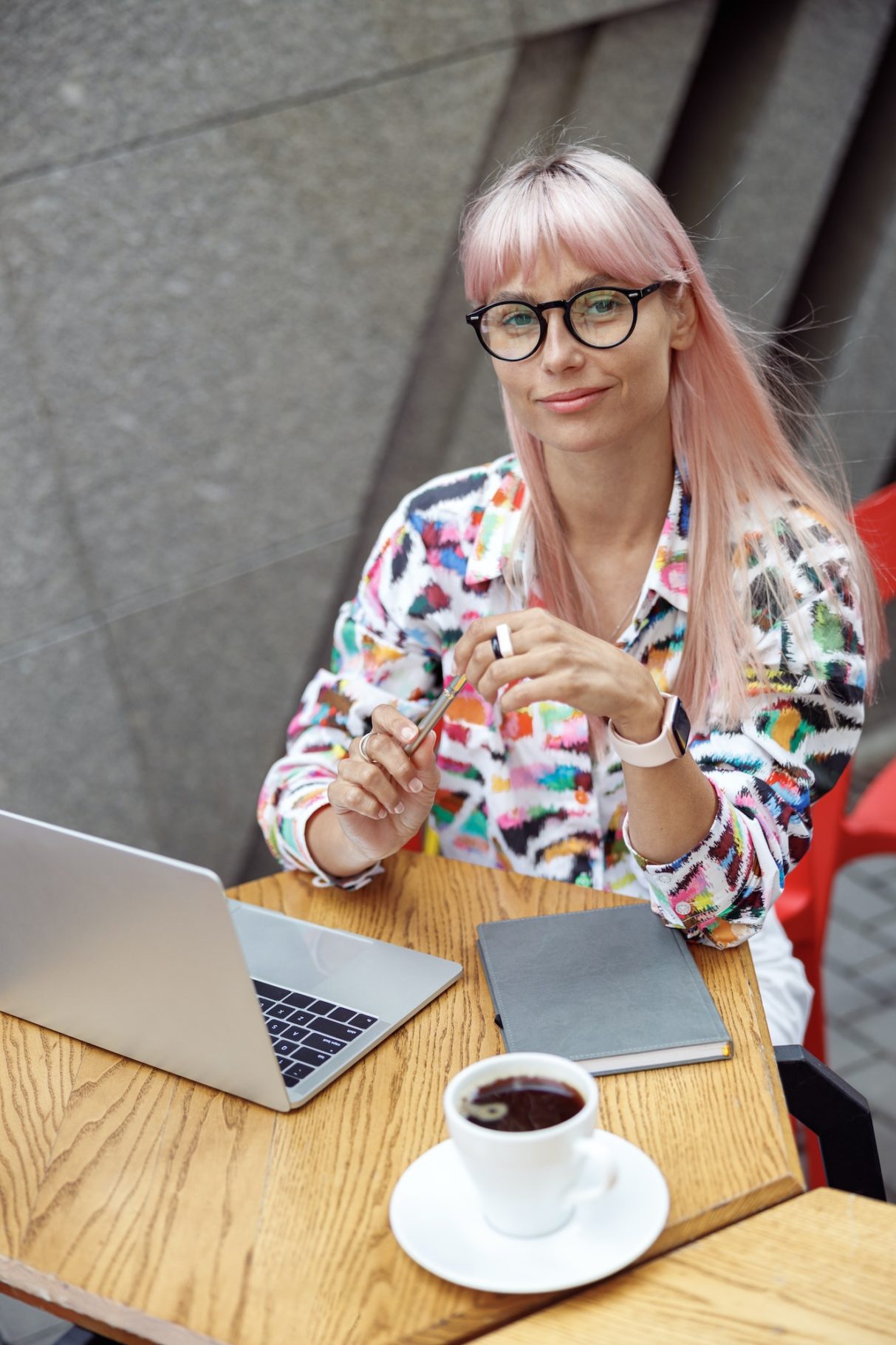 Smart woman in glasses sitting at outdoor cafe table