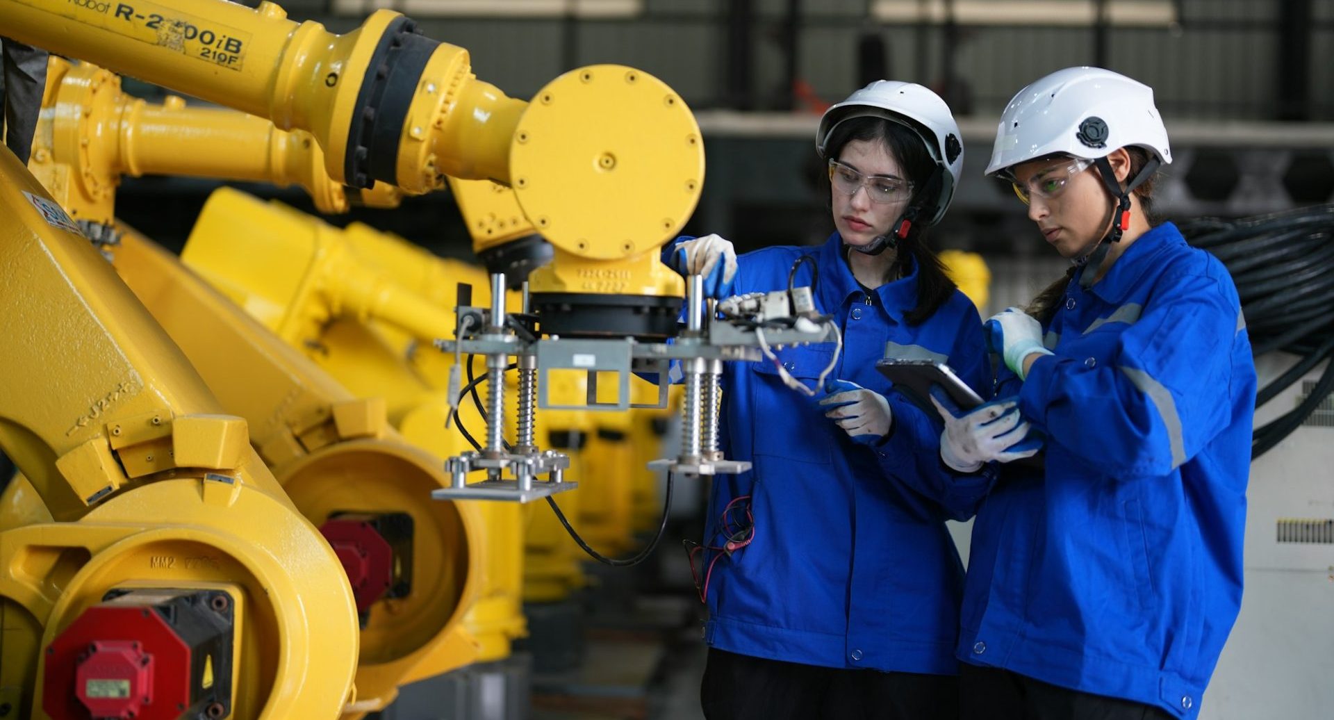 Robotics engineer working on maintenance of robotic arm in factory warehouse. Business technology.