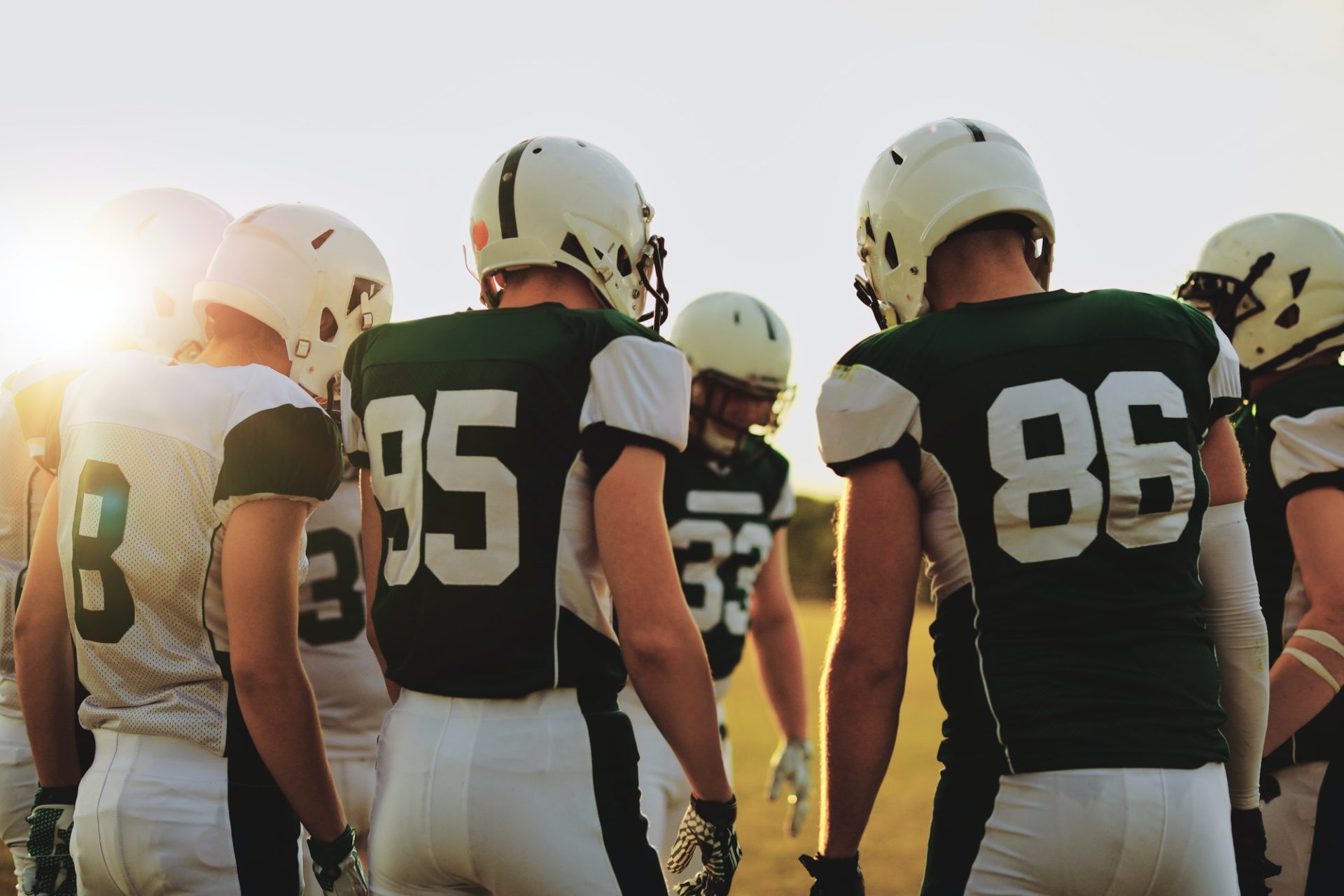 American football players standing in a huddle before a game