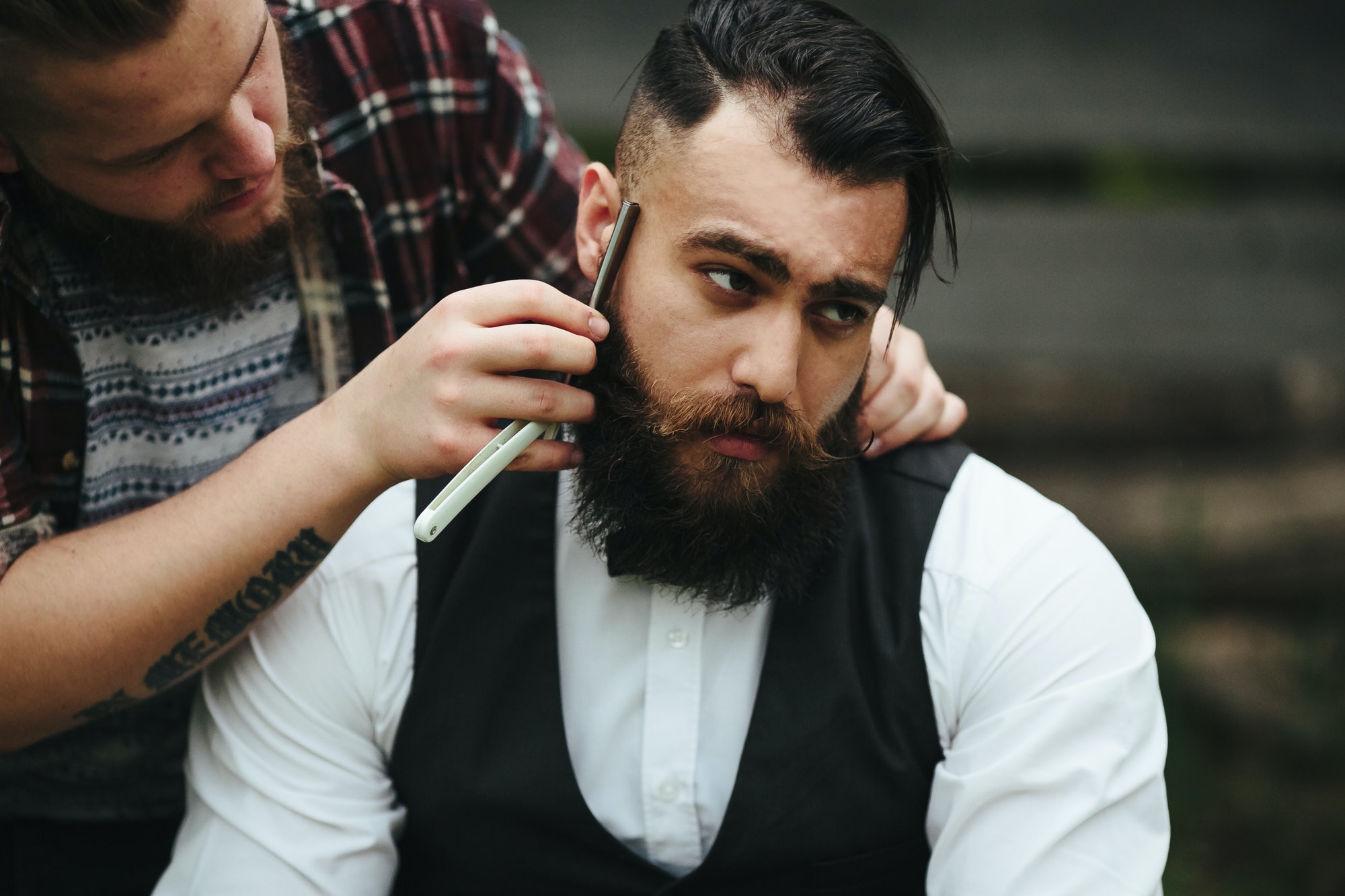 barber shaves a bearded man