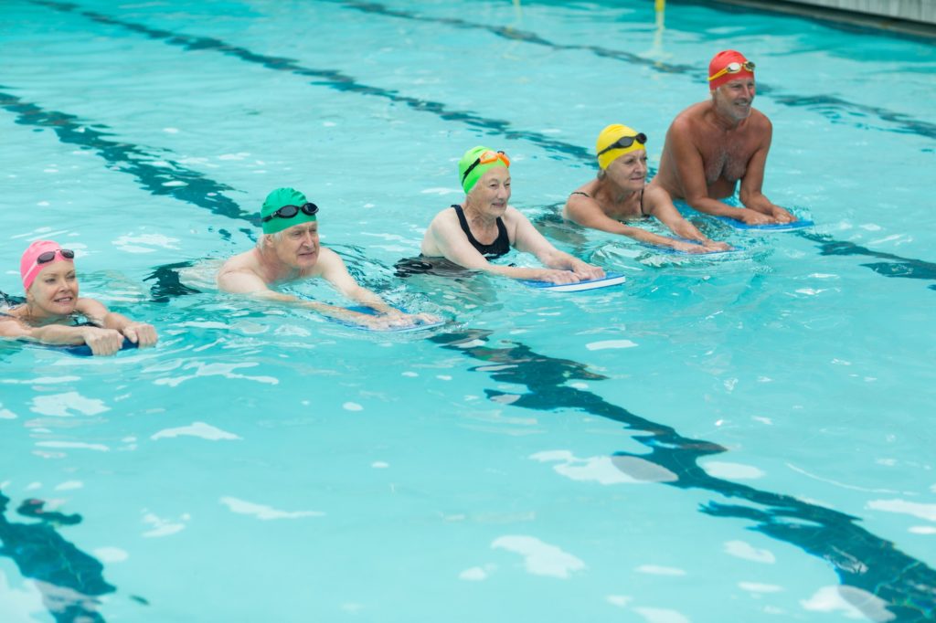 Swimmers with kickboards swimming in pool