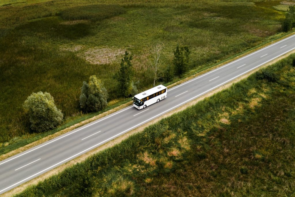 Aerial view of passenger bus on road through countryside