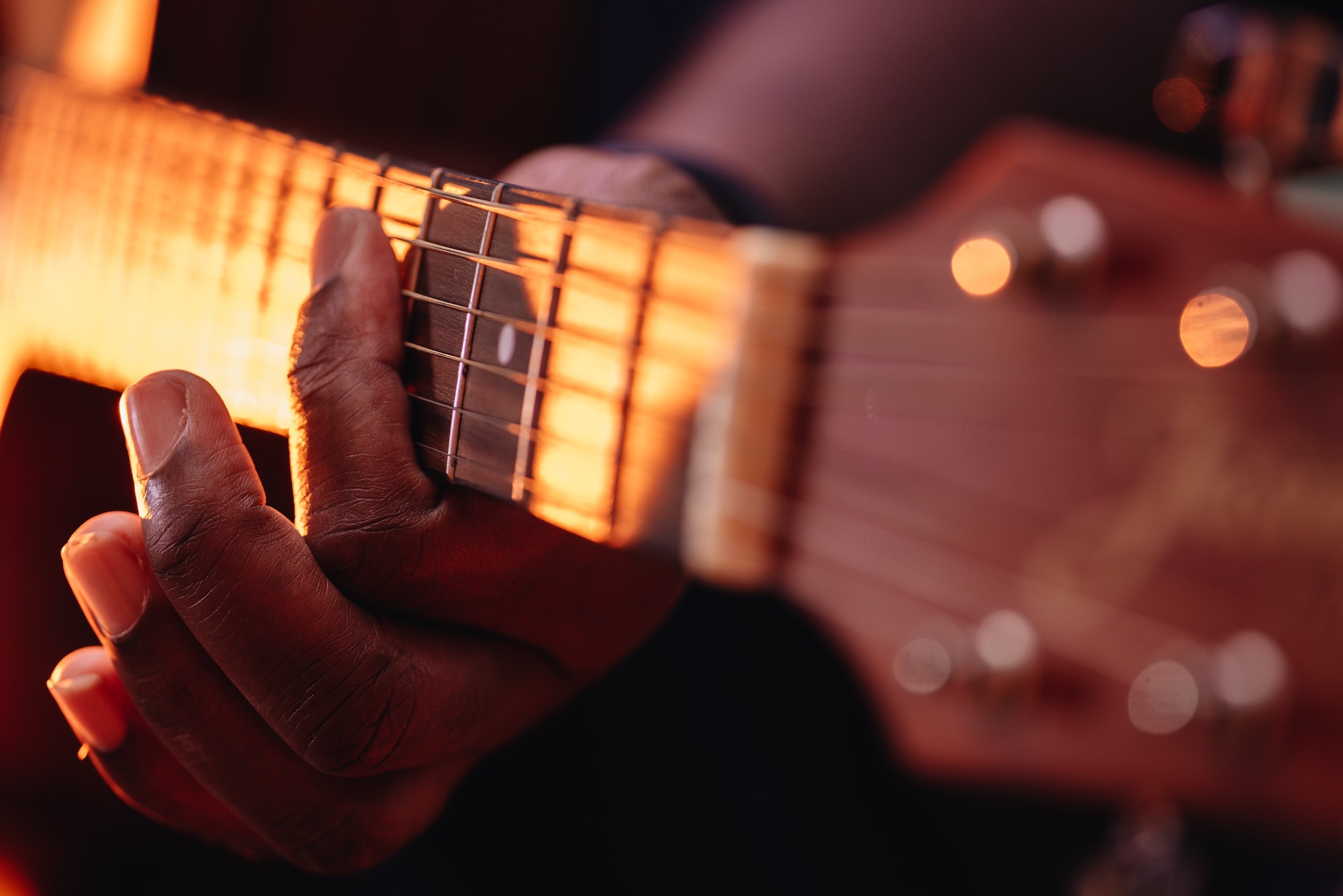 Close up of African American or black man playing an acoustic guitar
