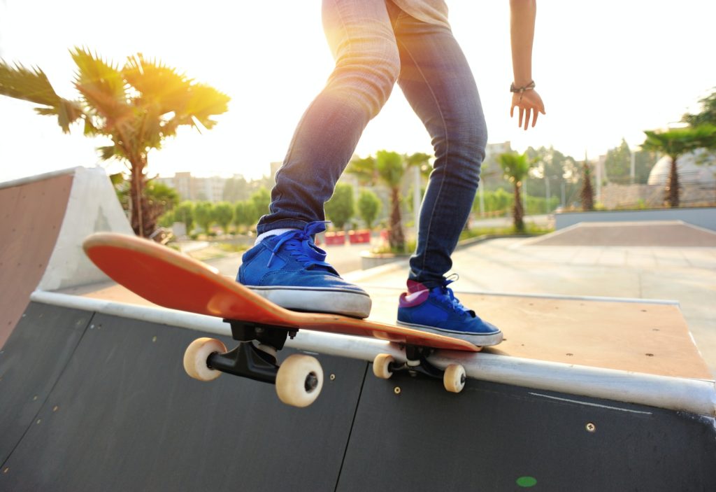 Skateboarder skateboarding at sunrise skatepark