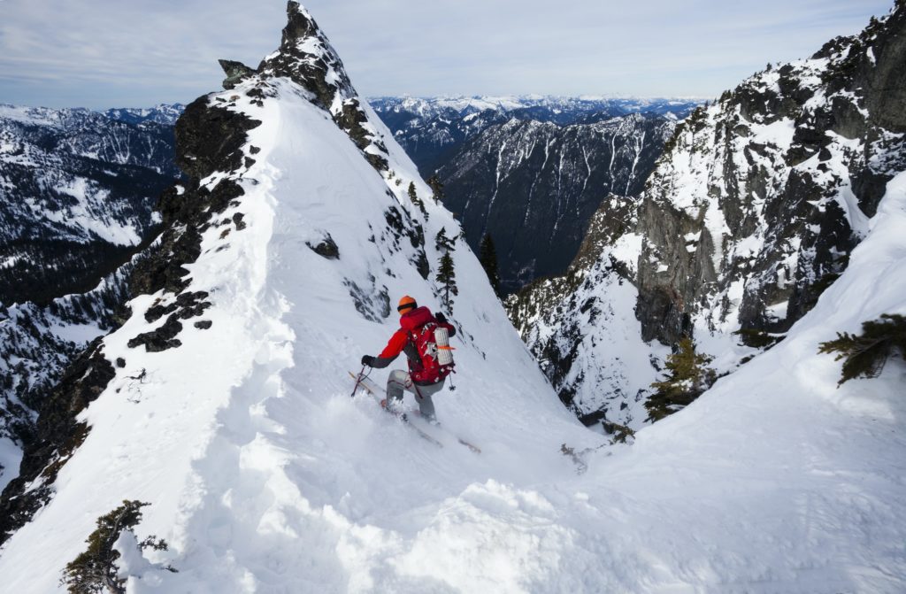 A skier ski-ing down a snow slope, powder skiing in the mountains in winter
