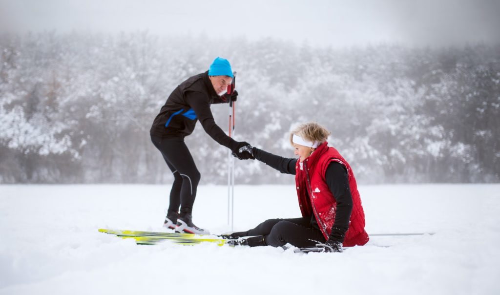 A senior couple cross-country skiing in winter.