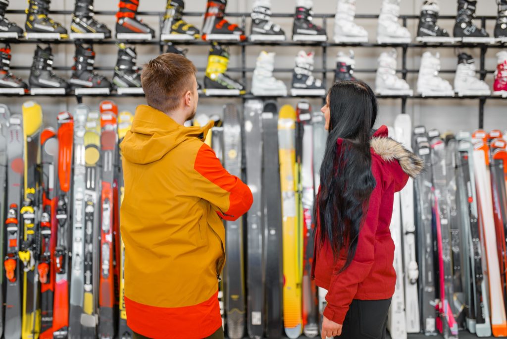 Couple choosing skiing or snowboarding equipment