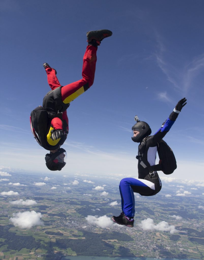 Team of two female skydivers in sit fly and head down positions over Buttwil, Luzern, Switzerland