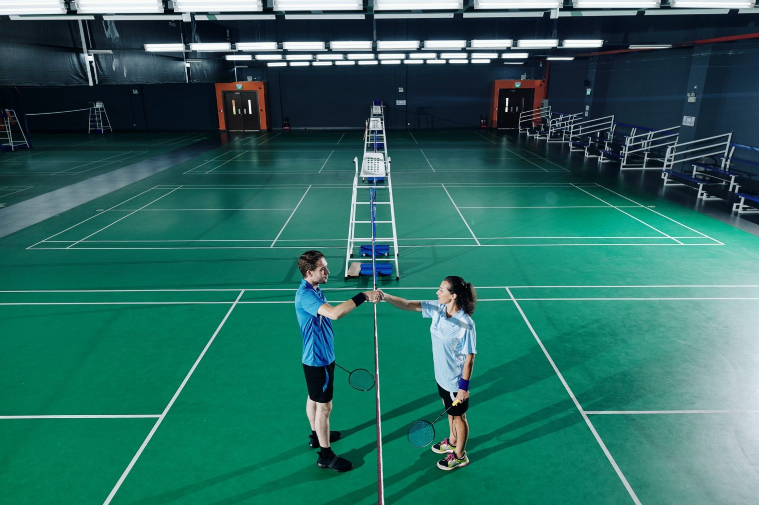 Badminton players training in gymnasium