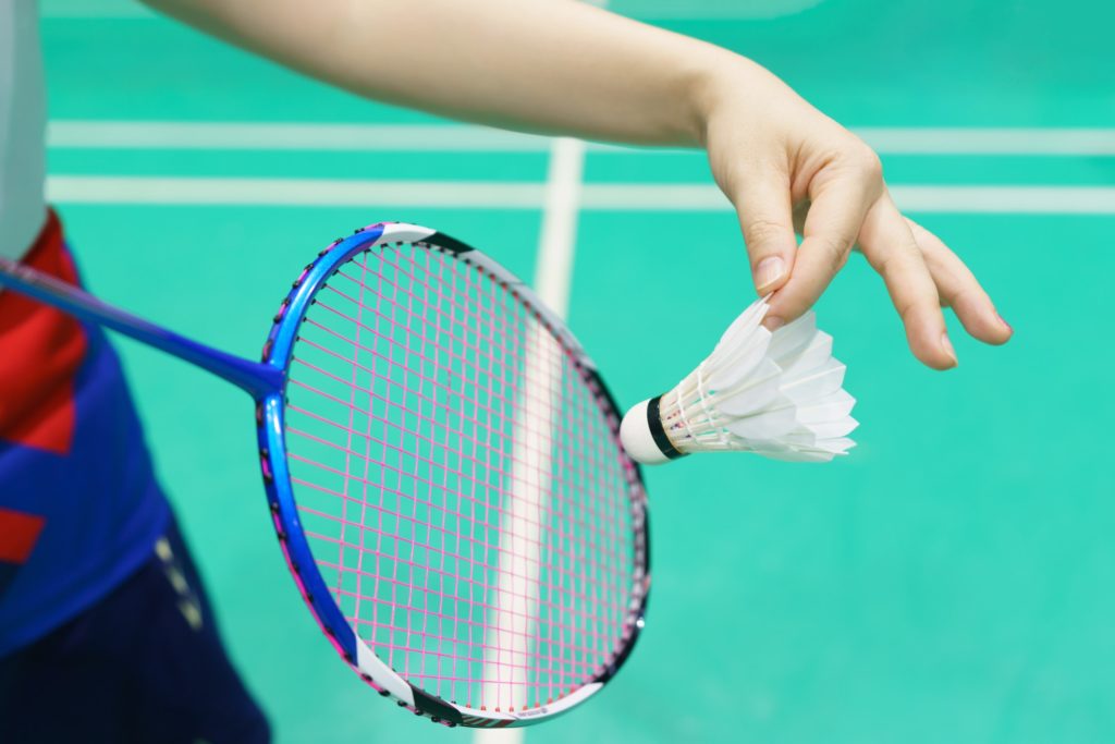 woman holding a badminton racket ready to hit shuttecock