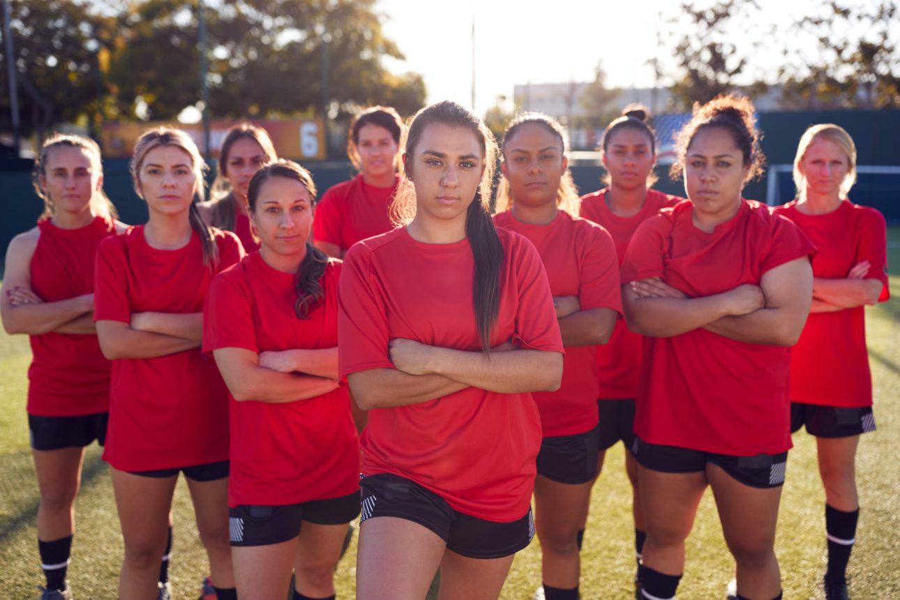 Portrait Of Womens Football Team Training For Soccer Match On Outdoor Astro Turf Pitch