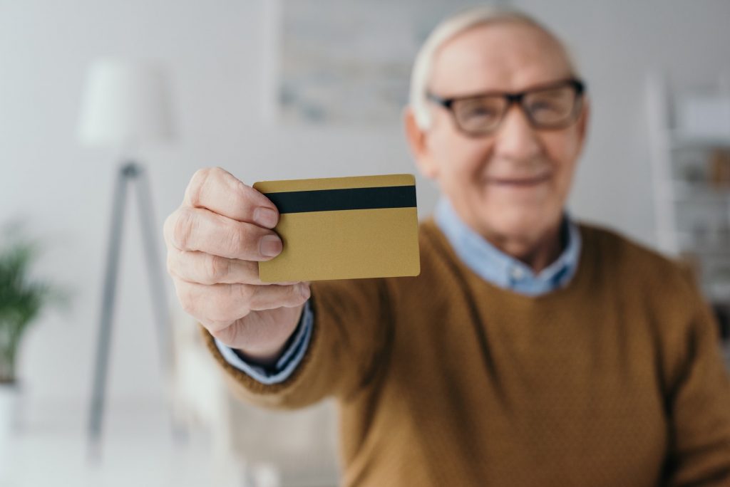 Senior smiling man holding credit card