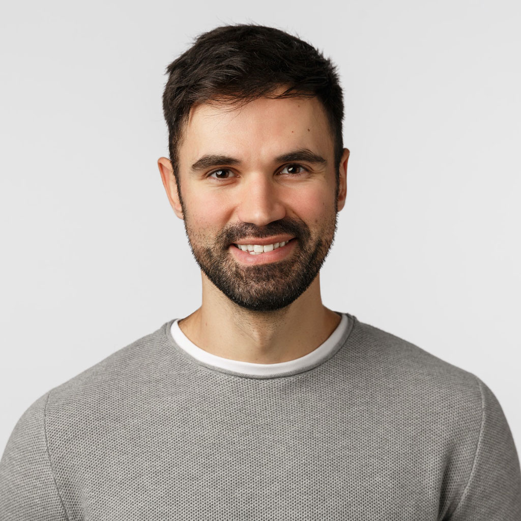 Motivated cheerful and glad, pleasant caucasian adult bearded man in grey sweater, smiling with