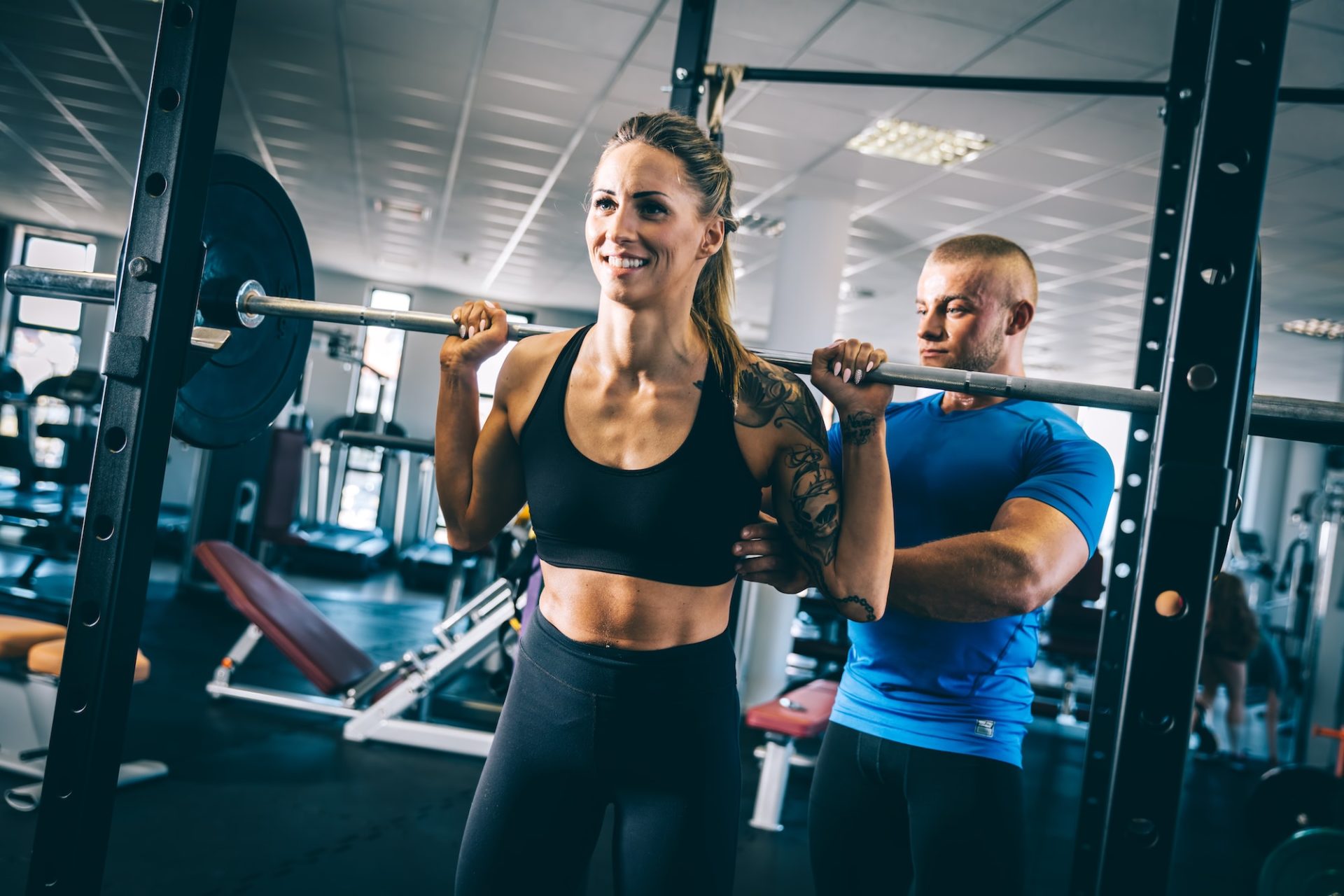 Man instructing a woman on a gym.