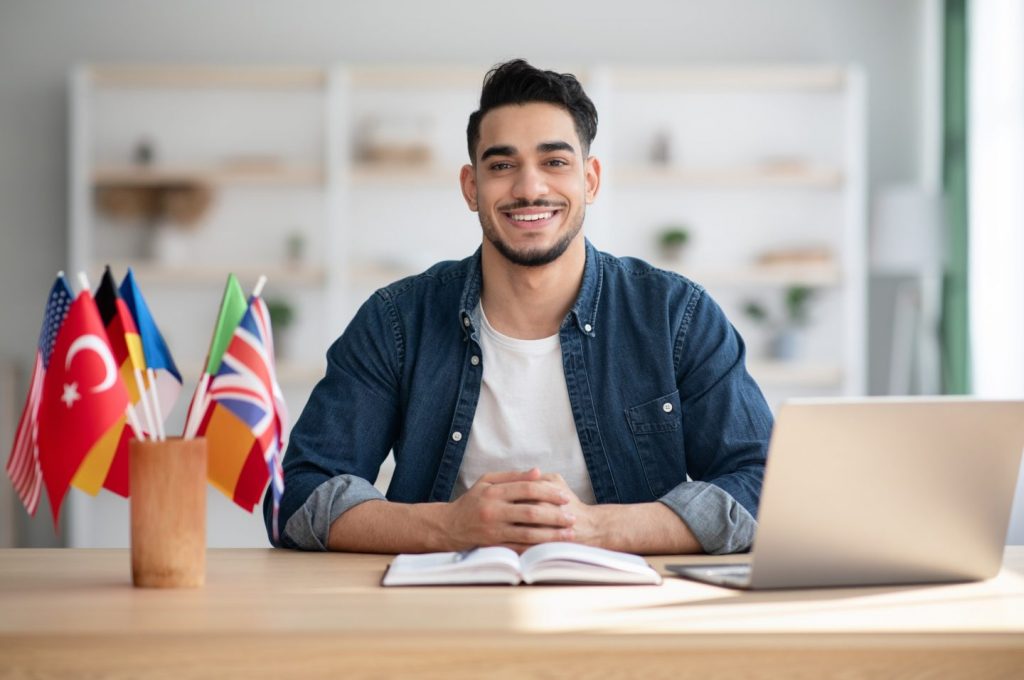 Cheerful arab guy having online class on laptop at home
