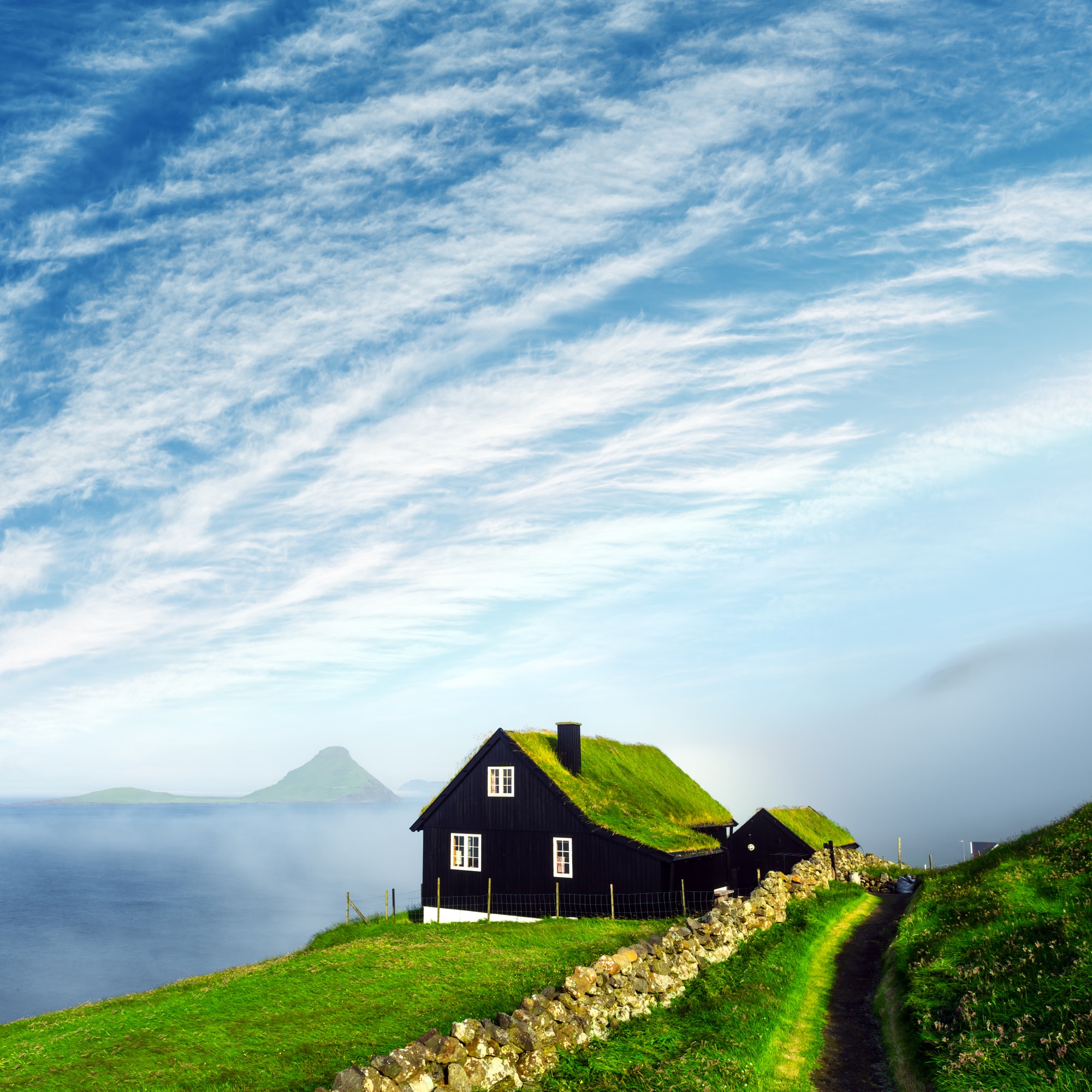 Foggy morning view of a house with typical grass roof
