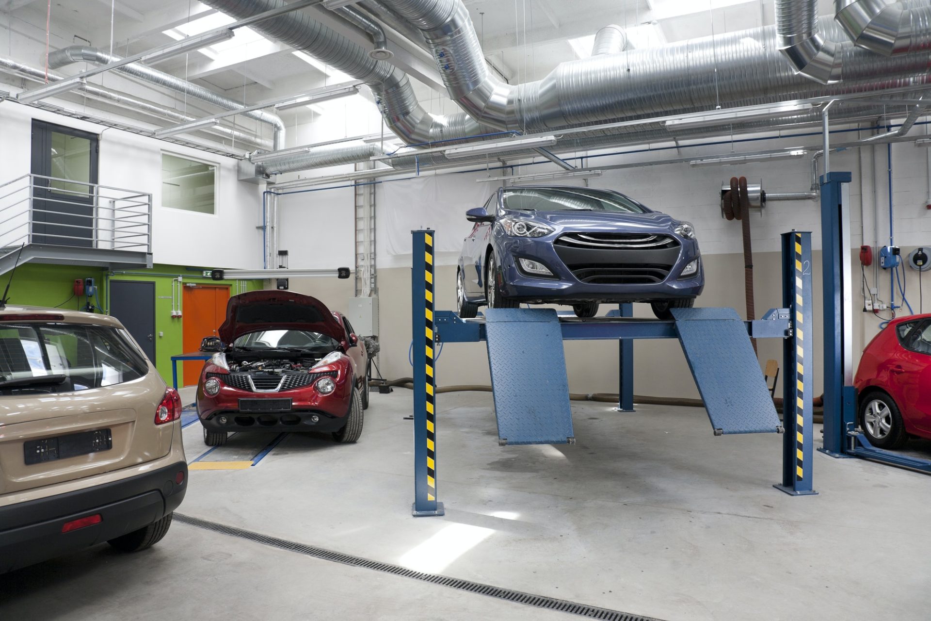 Cars in a large repair workshop or garage.