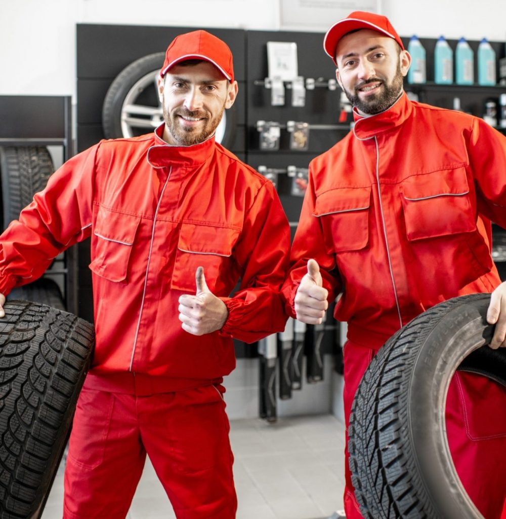 Car service workers with new tires at the shop
