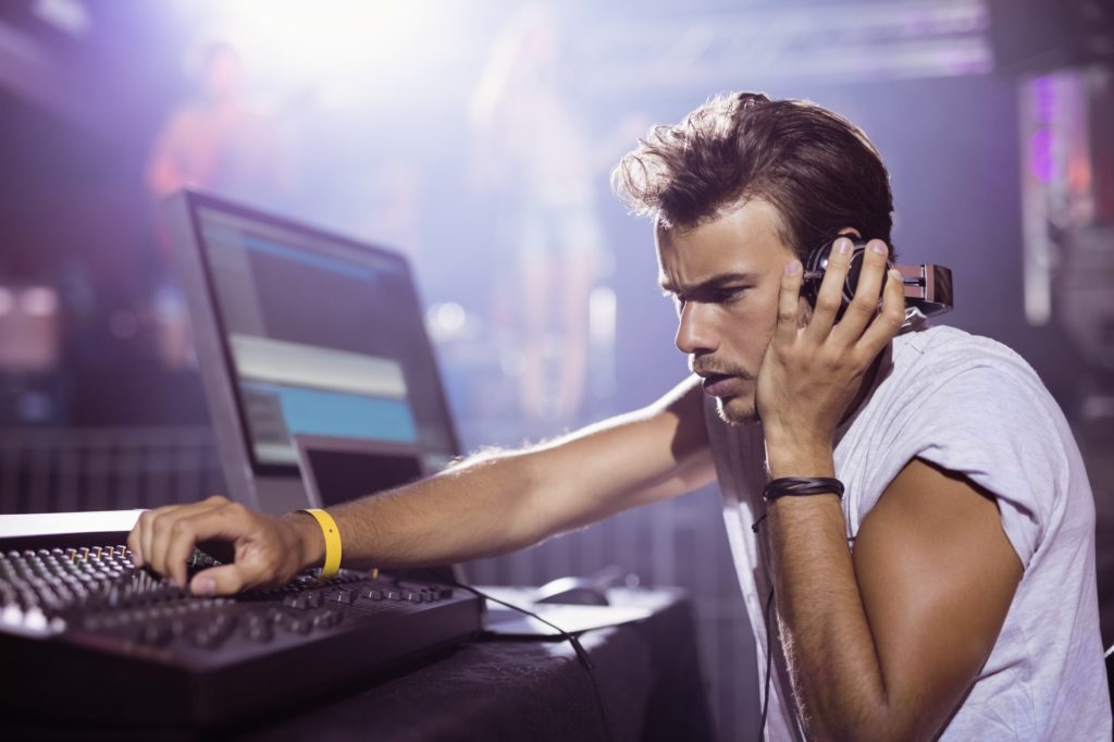 Young male dj performing at nightclub