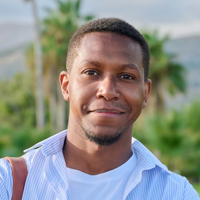 Outdoor portrait of African American man with crossed arms looking at camera